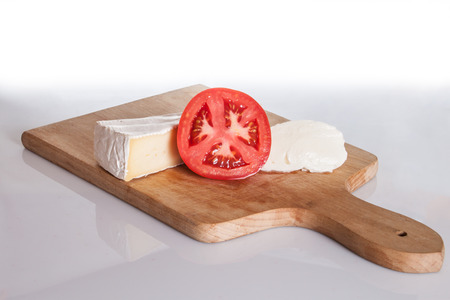 Brie cheese, mozzarella and tomato on a cutting board.の写真素材