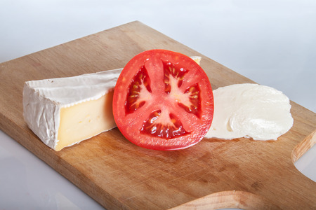 Brie cheese, mozzarella and tomato on a cutting board.の写真素材