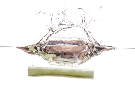 Cucumber slice falling in the waterの写真素材