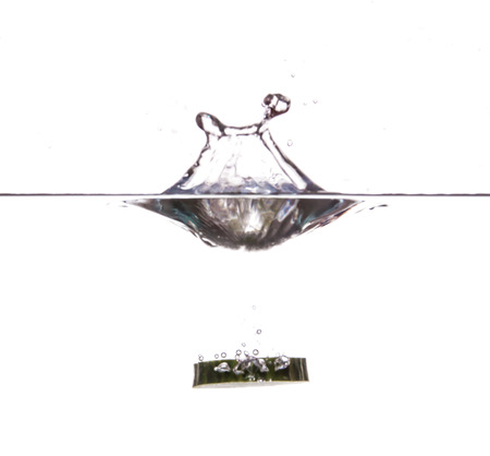 Slice of cucumber sinking underwaterの写真素材
