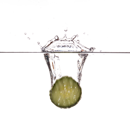 Slice of cucumber sinking underwaterの写真素材