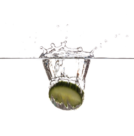 Slice of cucumber sinking underwaterの写真素材