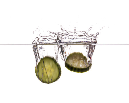 Slice of cucumber sinking underwaterの写真素材