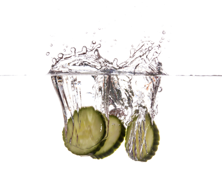 Slice of cucumber sinking underwaterの写真素材