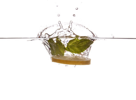 Lemon slice and mint sinking underwaterの写真素材
