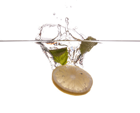 Lemon slice and mint sinking underwaterの写真素材