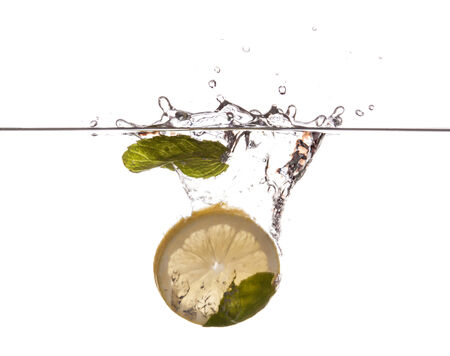 Lemon slice and mint sinking underwaterの写真素材