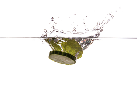 Cucumber slice and mint sinking underwaterの写真素材