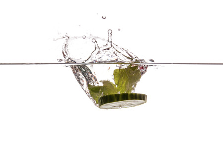 Cucumber slice and mint sinking underwaterの写真素材