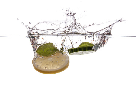 Cucumber slice and mint sinking underwaterの写真素材