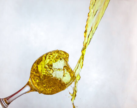 Interesting way for pouring yellow drink in a glassの写真素材