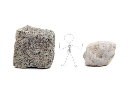 A paperclip figure standing between paving stone and a marble stoneの写真素材