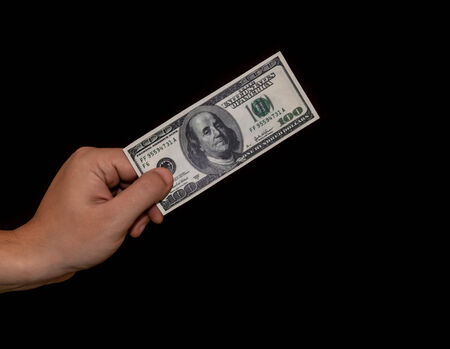 Human hand holding a 100 dollar billの写真素材