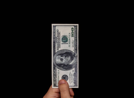 Human hand holding a 100 dollar bill
