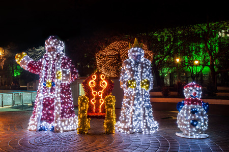 Santa Claus and Snow White statues decorated with lightsの写真素材