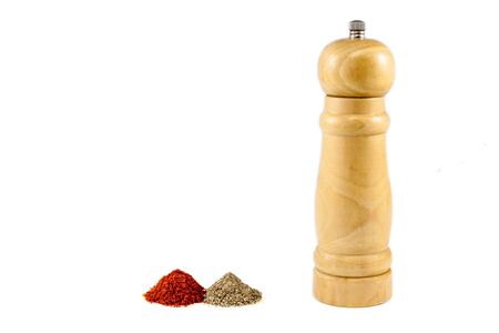 Pepper mill with piles of red and black pepper powderの写真素材