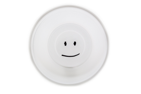 White plastic cup with a smiley face on the bottomの写真素材