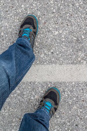 A men crossing white lane. First person view.の写真素材