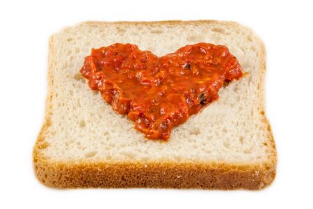I love lutenica concept. Traditional Bulgarian relish spead as a heart shape on a white bread.の写真素材