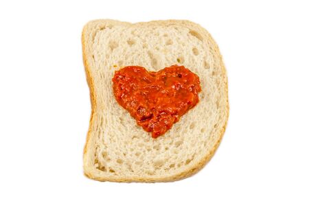 I love lutenica concept. Traditional Bulgarian relish spead as a heart shape on a white bread.の写真素材