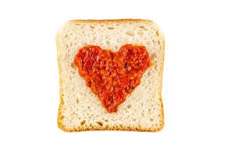 I love lutenica concept. Traditional Bulgarian relish spead as a heart shape on a white bread.の写真素材