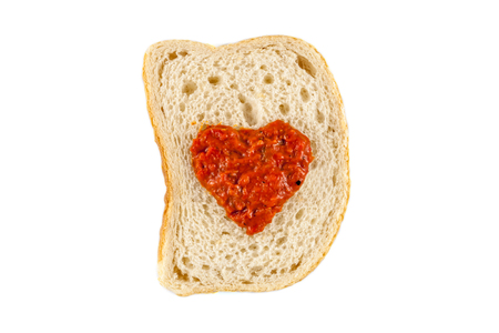 I love lutenica concept. Traditional Bulgarian relish spead as a heart shape on a white bread.の写真素材