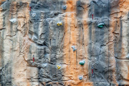 Multicolored climbing wall with support equipment on it.の写真素材