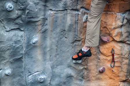 Human legs supporting themselves on a climbing wallの写真素材