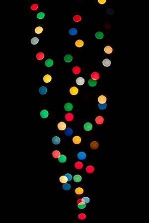 Cone shaped lights with different colors defocused and isolated on black background.の写真素材