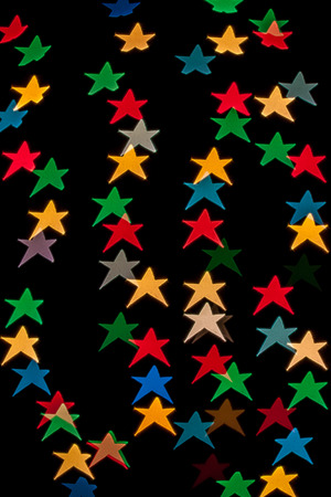 Star shaped qustom bokeh created from decoration lights and isolated on black background.の写真素材