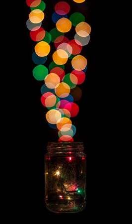 Collecting bokeh bubbles lights in a jar. Isolated on black background.の写真素材