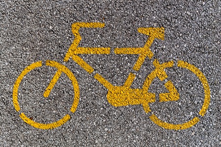 Bike lane sign painted on an asphalt road.
