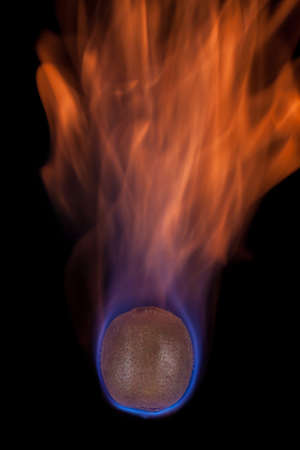 Kiwi on fire with blue flames isolated on black background