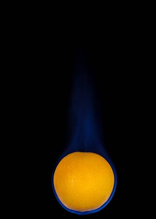 Orange on fire with blue flames isolated on black backgroundの写真素材