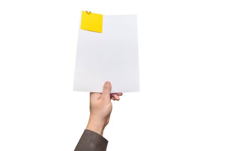 Human hand holding a sheet of paper with a yellow note on it. The note is attached with a heart shaped paperclip.の写真素材