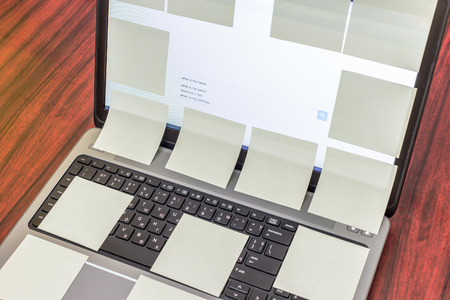 Laptop display covered with yellow sticky notesの写真素材