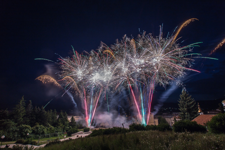 Fireworks display over the town of Panagyurishte, Bulgaria with blue sky in the background.の写真素材