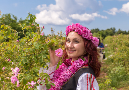 Bulgarian girl dressed in traditional dress picking roses during the Annual Rose Festival in Kazanlak, Bulgariaの写真素材