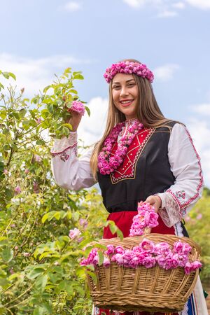 Bulgarian girl dressed in traditional dress picking roses during the Annual Rose Festival in Kazanlak, Bulgariaの写真素材