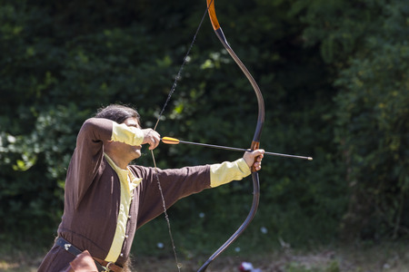 ASENVOGRAD, BULGARIA - JUNE 25, 2016 - Medieval fair in Asenovgrad recreating the life of Bulgarians during the Middle ages. Native american shooting a bow and arrow.のeditorial素材