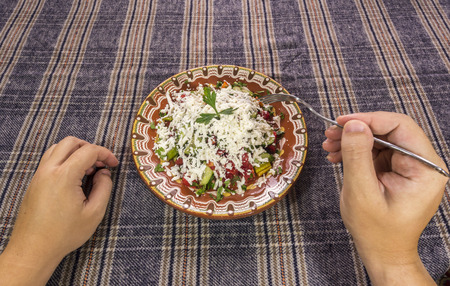 First person view of a man eating bulgarian Shopska salad.の写真素材