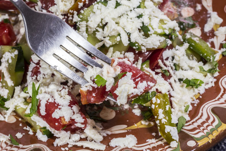 Macro shot of a traditional bulgarian salad called Shopska prick with a fork.の写真素材