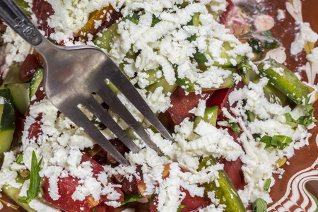 Macro shot of a traditional bulgarian salad called Shopska prick with a fork.の写真素材