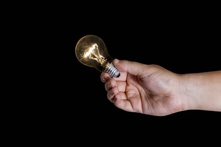 Human nad holding a lightbulb isolated on a black background. Having an idea concept.