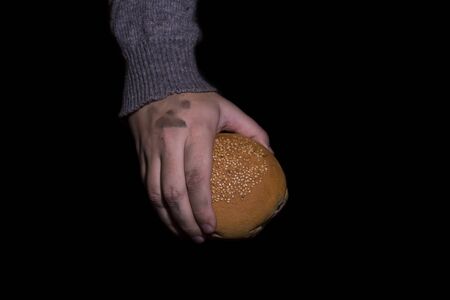 Poverty concept. Hands holding bread isolated on balck background.