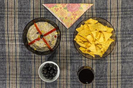 Above view of a bowl of tuna salad, tortilla chips, olives and glass of red wine.の写真素材