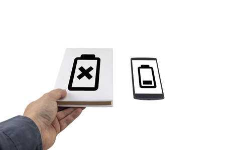 Hand taking a book instead of phone. New versus old concept. Low battery problem.の写真素材