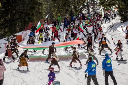 PAMPOROVO, BULGARIA - MARCH 03, 2017 - Skiing with Bulgarian flags at Pamporovo, Bulgaria. People dressed with traditional bulgarian clothes skiing with the national flag.のeditorial素材
