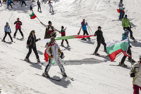 PAMPOROVO, BULGARIA - MARCH 03, 2017 - Skiing with Bulgarian flags at Pamporovo, Bulgaria. People dressed with traditional bulgarian clothes skiing with the national flag.のeditorial素材