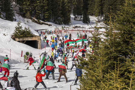 PAMPOROVO, BULGARIA - MARCH 03, 2017 - Skiing with Bulgarian flags at Pamporovo, Bulgaria. People dressed with traditional bulgarian clothes skiing with the national flag.のeditorial素材